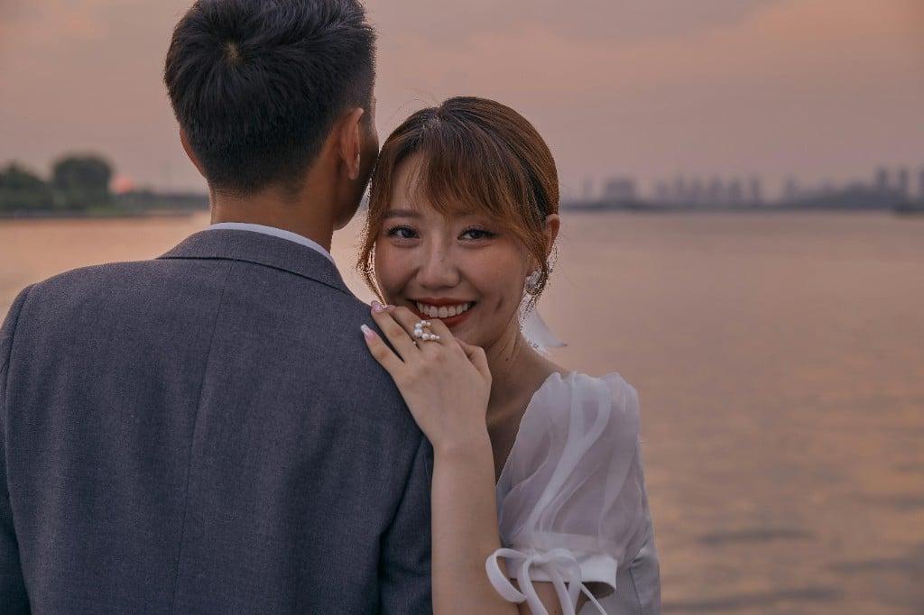 海边夕照下,新娘回眸轻笑、依偎在新郎肩头